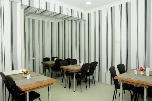 a dining room with tables and chairs and striped walls at Family Hotel Chino in Borjomi