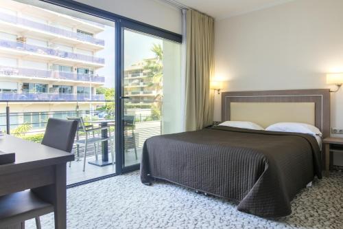 Cette chambre d'hôtel comprend un lit et un balcon. dans l'établissement Villa Azur, à Villeneuve-Loubet