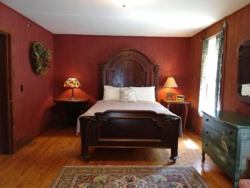 a bedroom with a large bed with red walls at The Woods Inn in Inlet