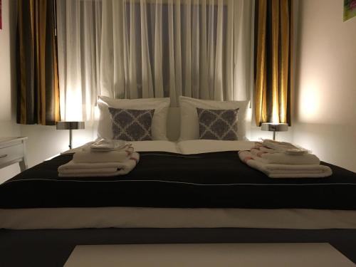 a bedroom with a large bed with two lamps on it at E&M Apartments Düsseldorf in Düsseldorf