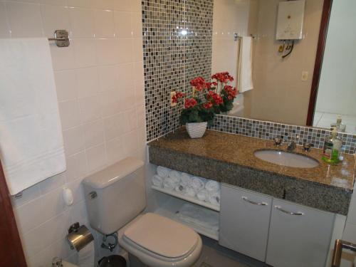 a bathroom with a toilet and a sink at Alto Estilo Barra Posto 8 in Rio de Janeiro