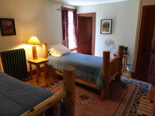 a bedroom with two beds and a lamp on a table at The Woods Inn in Inlet