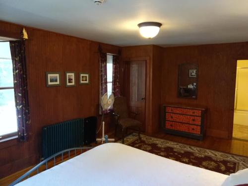 a bedroom with a white bed and wooden walls at The Woods Inn in Inlet