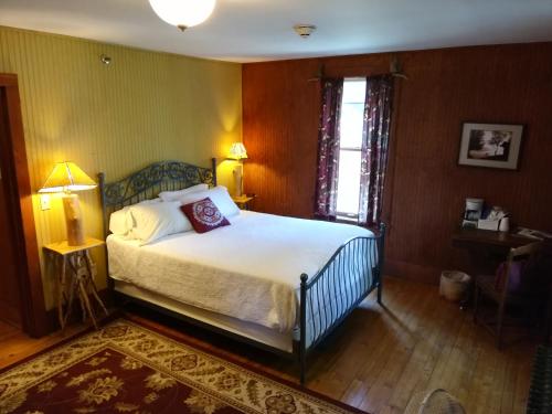 a bedroom with a bed and a lamp and a window at The Woods Inn in Inlet