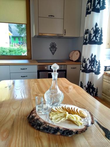 a plate with a glass vase on a table at Góralskie Domki na Podhalu - z jacuzzi in Maniowy