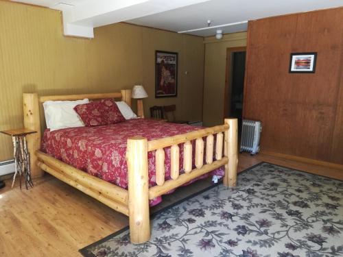 a bedroom with a wooden bed in a room at The Woods Inn in Inlet