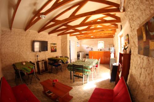 a living room filled with furniture and a tv at Hostal Mamatierra in San Pedro de Atacama