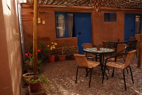 un patio con mesa, sillas y plantas en Hostal Mamatierra en San Pedro de Atacama
