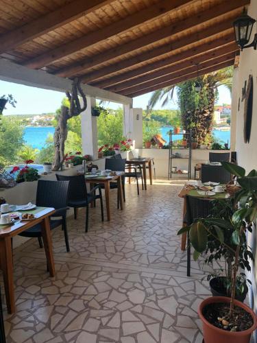 a restaurant with tables and chairs on a patio at Guesthouse Tamara in Lovište