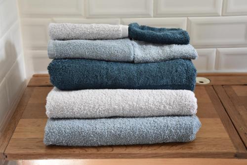 a stack of towels sitting on a wooden floor at La buissonnière in Leuilly-sous-Coucy