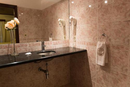 a bathroom with a sink and a mirror at Hotel Termas Day in Termas del Daymán