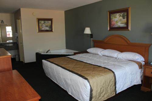 een hotelkamer met een bed en een bad bij Nationwide 9 Inn in Wynne