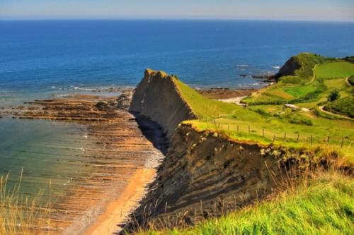 a view of a cliff next to the ocean at Espacio amplio y luminoso in Zumaia
