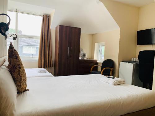 um quarto de hotel com duas camas e uma janela em Albert Guest House em Kingston upon Thames