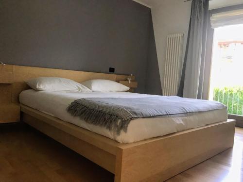 una camera con letto con testiera in legno e finestra di Movisod 66 - Aosta - CIR VDA-AOSTA-0163 ad Aosta