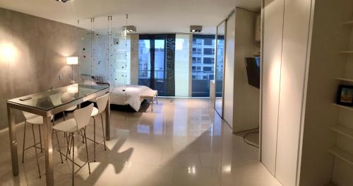 een woonkamer met een glazen tafel en een bed bij Soho Luxury Loft in Buenos Aires