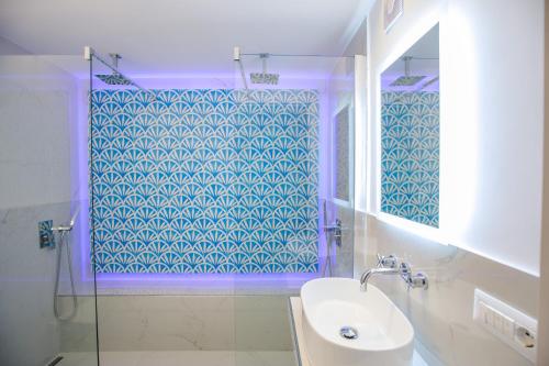 カプリにあるJUNIORSUITEB&Bのバスルーム(シンク、青いタイルのシャワー付)