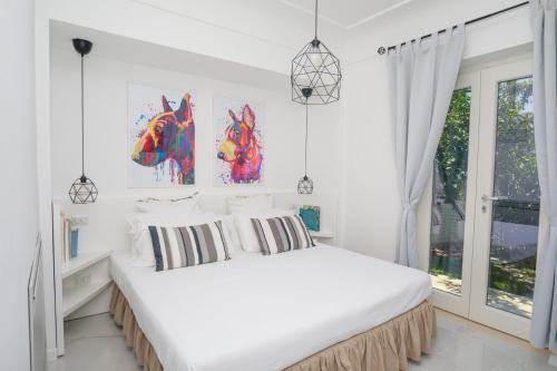 a white bedroom with a bed with two paintings of horses on the wall at JUNIORSUITEB&B in Capri