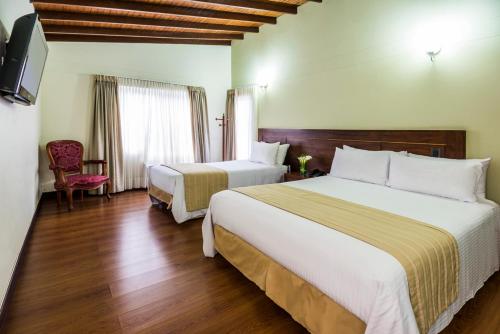 Un pat sau paturi într-o cameră la Hotel Portales Del Campestre