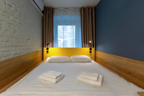a bedroom with a large white bed with two towels on it at Axel Hotel Moscow in Moscow