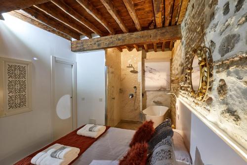 1 dormitorio con cama y pared de piedra en Lofts amantes de Toledo -LOFT COBERTIZO, en Toledo