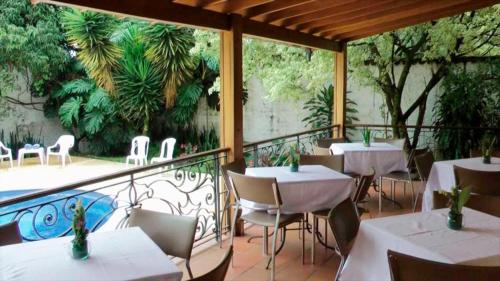 a restaurant with tables and chairs on a balcony at Hotel Portales Del Campestre in Medellín