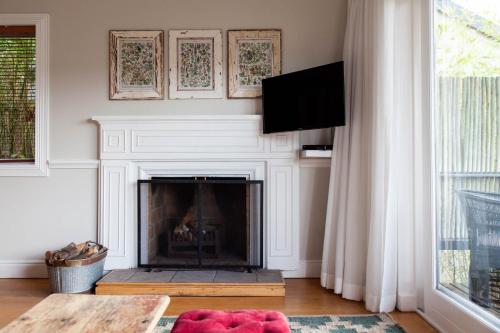 a living room with a fireplace and a tv at Emily Moon River Lodge in Plettenberg Bay