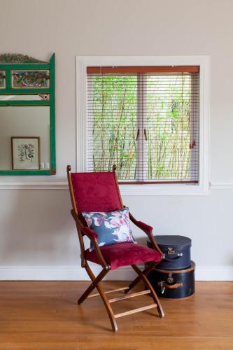 a red chair sitting in a room with a window at Emily Moon River Lodge in Plettenberg Bay