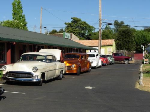 a row of old cars parked in a parking lot at Jumping Frog Motel in Angels Camp