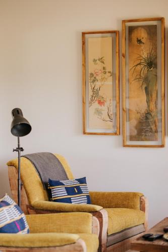 a living room with two couches and pictures on the wall at Emily Moon River Lodge in Plettenberg Bay