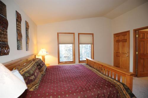 a bedroom with a bed and two windows at 72 Clubhouse in Breckenridge