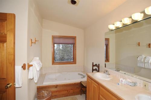 a bathroom with a tub and two sinks and a mirror at 72 Clubhouse in Breckenridge