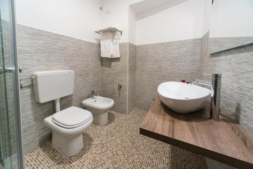 a bathroom with a toilet and a sink and a tub at Le Undici Rose Hotel in Viterbo
