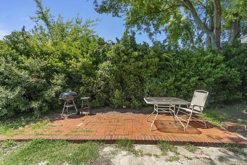 a patio with a grill and a table and chairs at Charming Waterfront Cabin Cabin in Norfolk