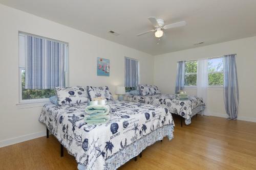 1 dormitorio con 2 camas y ventilador de techo en Harbor Delight On The Bay - Private Sandy Beach! Home, en Norfolk