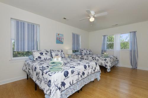 um quarto com 2 camas e uma ventoinha de tecto em Harbor Delight On The Bay - Private Sandy Beach! Home em Norfolk