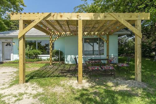 pérgola de madera con mesa y sillas en un patio en Charming Waterfront Cabin Cabin en Norfolk