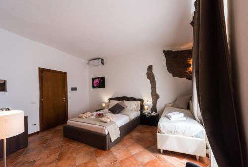 a bedroom with a bed and a couch in a room at Le Undici Rose Hotel in Viterbo