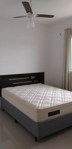 uma cama num quarto com uma ventoinha de tecto em Conjunto Residencial Verdes Mares em Guaratuba