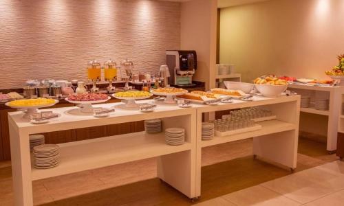a buffet with many bowls of food on a table at Ed Saint Moritz, Flat 02 com Garagem, SHN no Coração de Brasília in Brasilia