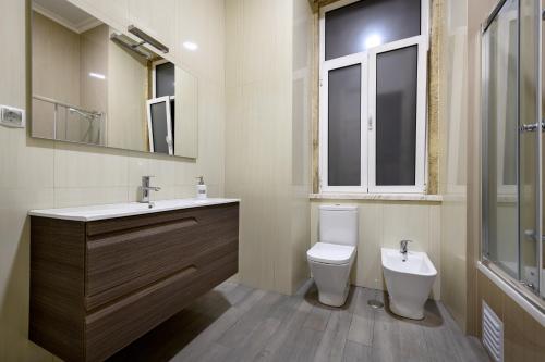 a bathroom with a toilet, sink, and bathtub at Pensao Londres in Lisbon