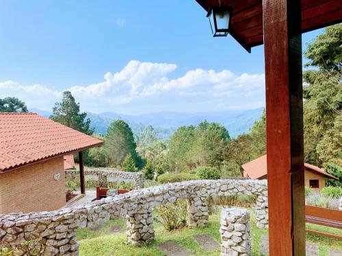 a stone wall with a view of the mountains at Pousada Cantinho das Estrelas in Monte Verde