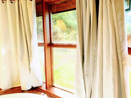 a window with white curtains in a room at Pousada Cantinho das Estrelas in Monte Verde