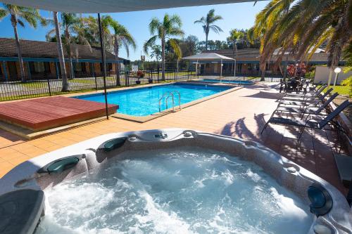 una piscina con vasca idromassaggio in un cortile di Seashells Beachfront Resort a Diamond Beach