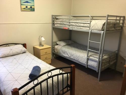 a bedroom with two bunk beds and a bed at Kickback Cottages in Lakes Entrance