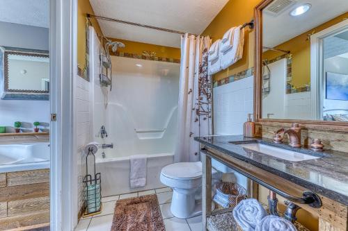 a bathroom with a toilet and a sink and a tub at Golf View Condo in Pigeon Forge