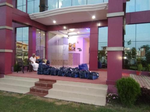 a man sitting on a couch in front of a building at Hotel the Ideal in Kushinagar
