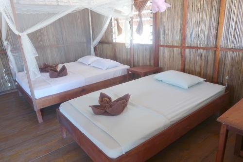 A bed or beds in a room at Atauro Dive Resort