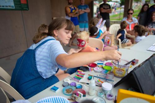 a woman holding a child at a table with toys at BIG4 Apollo Bay Pisces Holiday Park in Apollo Bay