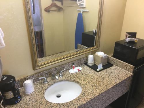 a bathroom with a sink and a mirror at Days Inn by Wyndham Yazoo City in Yazoo City